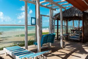 a playground with two blue chairs and the beach at Pousada La Bella Luna in Porto De Galinhas