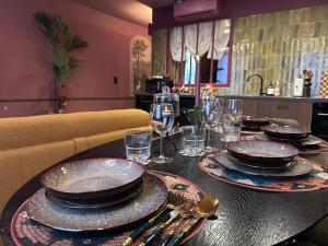 a table with plates and glasses on top of it at LE PORTO RICO, Hypercenter, Air conditioning in Mâcon +59 photos