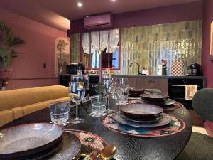 a dining room table with plates and glasses on it at LE PORTO RICO, Hypercenter, Air conditioning in Mâcon