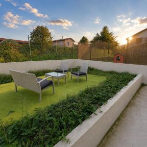a patio with chairs and a table in a garden at borgo nel vigneto 2 in Erbusco