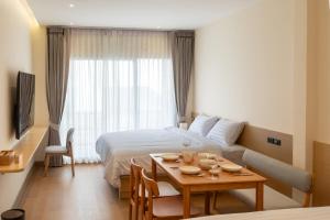 a hotel room with a bed and a table at Acoz in Ban Zong Katiam