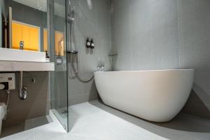 a bathroom with a white tub and a shower at Acoz in Ban Zong Katiam +64 photos
