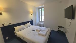 a bedroom with a bed with two towels on it at L'hostellerie de la vallée in Gimel