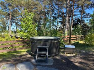 a wooden barrel with a chair sitting next to a fence at Dimantu nami in Upesgrīva +7 photos
