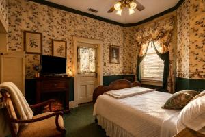 a bedroom with a bed and a tv in it at Four Winds Victorian Venue & Suites in Bonham +53 photos
