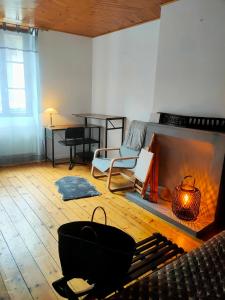 a living room with a fireplace and a table at La Maison bleue in Rossillon