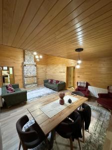 a living room with a wooden ceiling and a wooden table at TRIA APART OTEL in Uzungöl