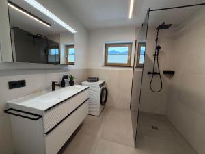 a bathroom with a sink and a washing machine at Mountain hOMES in Axams