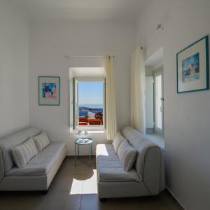 a living room with two couches and a window at Kamares Neoklassiko in Fira