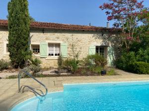 a swimming pool in front of a house at La Bordeneuve - Chambre d'hôtes in Auch