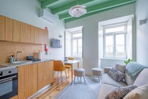 a kitchen and living room with a couch and a table at Figueirinhas Home Green in Coimbra +19 photos