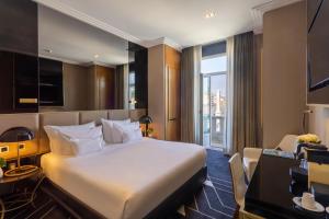 a hotel room with a large bed and a window at Altis Avenida Hotel, a member of Preferred Hotels & Resorts in Lisbon +24 photos