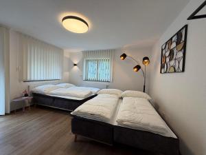 two beds in a room with two lamps and a room with two at Mountain hOMES in Axams