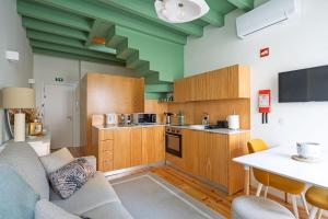 a kitchen with a couch and a table in a room at Figueirinhas Home Green in Coimbra