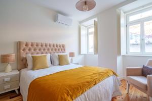 a bedroom with a large bed with a yellow blanket at Figueirinhas Home Green in Coimbra