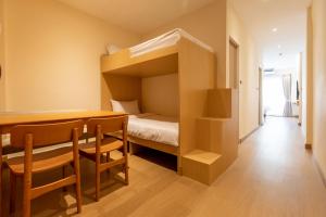 a small room with a bed and a table and chairs at Acoz in Ban Zong Katiam