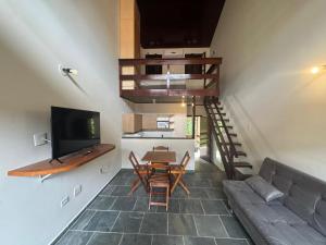 a living room with a couch and a table and a tv at Hotel da Ilha in Ilhabela
