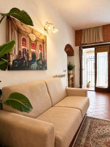 a living room with a couch and a painting on the wall at Residenza Vittoria nell'Antico Borgo in Piombino +11 photos
