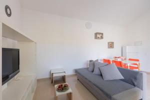 a living room with a blue couch and a tv at Blue Río Playa, Casa & Studio in Costa Calma