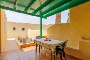 a patio with a table and chairs in a room at Blue Río Playa, Casa & Studio in Costa Calma
