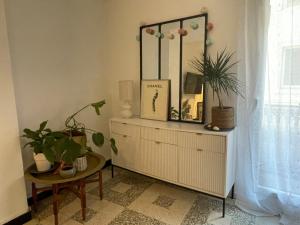 a mirror on a dresser in a room with plants at Giovanna in Marseillan