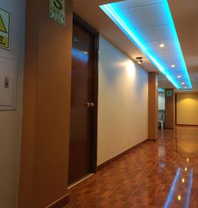 um corredor vazio com uma porta e uma luz azul em Casa Suite em Juliaca