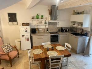 a kitchen with a table and chairs and a refrigerator at Giovanna in Marseillan