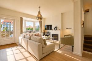 a living room with a couch and a table at Villa Duinbergen - Séjour Familial à Knokke-Heist in Knokke-Heist