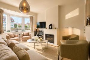 a living room with a couch and a fireplace at Villa Duinbergen - Séjour Familial à Knokke-Heist in Knokke-Heist