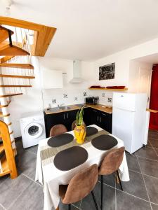 a kitchen with a table and chairs in a room at L'échappée Verte en Thiérache in Martigny +3 photos