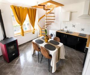 a kitchen with a table with chairs and a stove at L'échappée Verte en Thiérache in Martigny