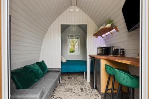 a living room with a couch in a house at The Hideaway - Tranquil Glamping Pod in Narberth +7 photos