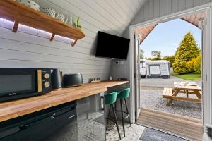 a kitchen with a counter with a television and a patio at The Hideaway - Tranquil Glamping Pod in Narberth