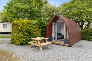 a small shed with a table and a bench at The Hideaway - Tranquil Glamping Pod in Narberth