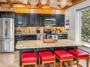 eine Küche mit schwarzen Schränken und roten Hockern in der Unterkunft Tree Top Condo in Vail