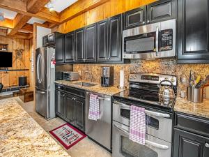 eine Küche mit Edelstahlgeräten und schwarzen Schränken in der Unterkunft Tree Top Condo in Vail