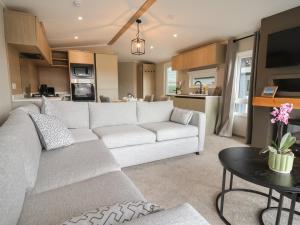 a living room with a white couch and a table at The Pines 2 Bedrooms in Northwich