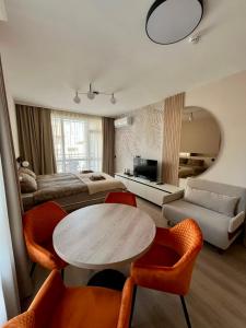 a living room with a table and chairs and a bed at Sorrento Pool View Apartment in Sveti Vlas