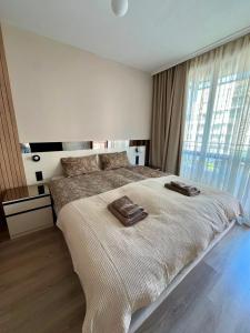 a bedroom with a large bed with two towels on it at Sorrento Pool View Apartment in Sveti Vlas +13 photos