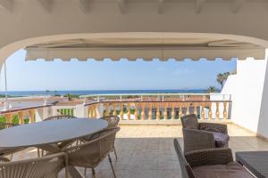 a balcony with a table and chairs and the ocean at Villa Sea Lights 89b in Son Bou
