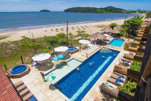 ペーニャにあるPousada Pedra da Ilhaのスイミングプールとビーチの景色を望めます。
