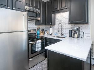 a kitchen with black cabinets and a stainless steel refrigerator at Vail 21 Condo 502 in Vail