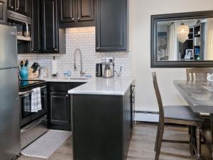 a kitchen with black cabinets and a stainless steel refrigerator at Vail 21 Condo 502 in Vail