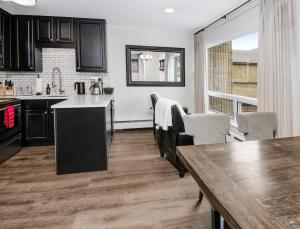 a kitchen with black cabinets and a wooden table at Vail 21 Condo 502 in Vail