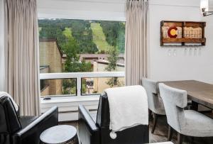 a dining room with a table and chairs and a large window at Vail 21 Condo 502 in Vail +15 photos