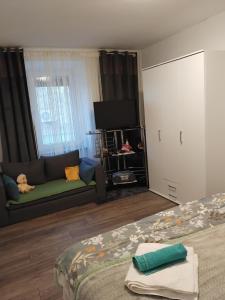 a bedroom with a bed and a couch and a tv at Nensi1 in Križišće