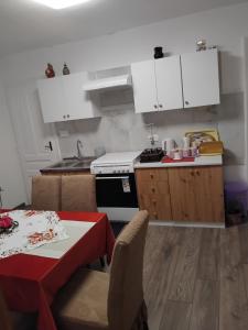 a kitchen with white cabinets and a table and a stove at Nensi1 in Križišće
