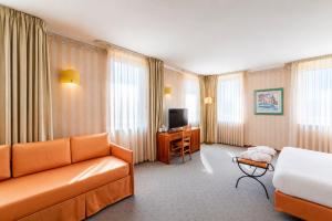 a hotel room with a couch and a desk at Phi Hotel Astoria in Susegana