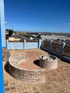 a brick fire pit on a patio with a view of the ocean at Sunrise Villa Self Catering and Accommodation in Lüderitz