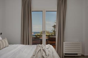a bedroom with a bed and a view of the ocean at Papi Boutique Hotel in Vathí